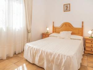 a bedroom with a white bed and a window at Holiday Home Las Tijeras by Interhome in Rute