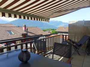 d'un balcon avec une table, des chaises et des montagnes. dans l'établissement Apartment Tilleul by Interhome, à Grimisuat