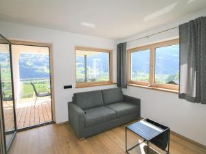 salon z kanapą i oknami w obiekcie Apartment Georg by Interhome w mieście Kaltenbach