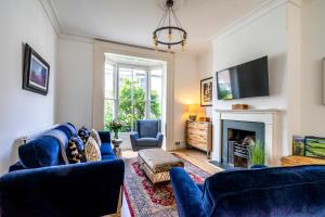 ein Wohnzimmer mit blauen Sofas und einem Kamin in der Unterkunft 9 St John's Street in York