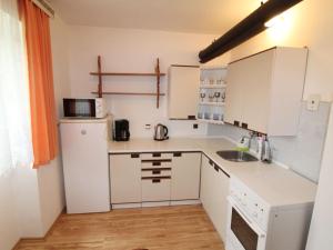 a small kitchen with white cabinets and a refrigerator at Holiday Home Vlhlavy u Hluboké by Interhome in Sedlec