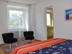 una camera da letto con due sedie e un letto e una finestra di Apartment Le Bolle by Interhome a Magadino