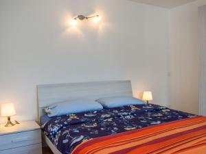 una camera da letto con un letto con cuscini blu e 2 lampade di Apartment Le Bolle by Interhome a Magadino