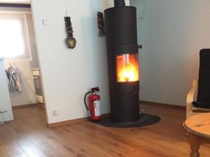 a wood stove in a living room with a fire extinguisher at Apartment Hostattstrasse 20 by Interhome in Engelberg