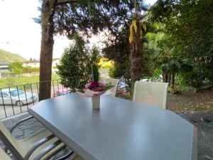 a table and two chairs with a vase on it at Holiday Home Casa ai Terreni dei Nonni by Interhome in Losone