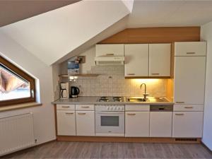 kuchnia z białymi szafkami i zlewem w obiekcie Apartment Apart 107 Wiesenhof by Interhome w mieście Kappl