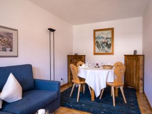 a dining room with a table and a blue couch at Apartment Chesa Palüdin 8 - Celerina by Interhome in Celerina