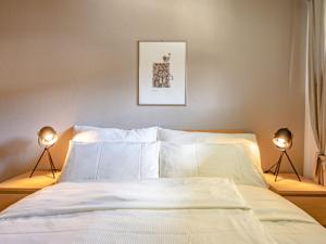 Un dormitorio con una cama con dos luces. en Apartment Chesa Palüdin 8 - Celerina by Interhome, en Celerina