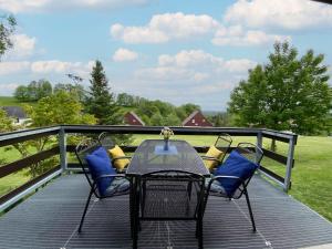 een tafel en stoelen op een terras met uitzicht op een veld bij Holiday Home Holiday Hill E52 by Interhome in Cerny Dul