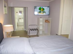 a bedroom with a bed and a tv on the wall at Holiday Home Philipp by Interhome in Loissin