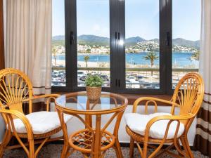 Zimmer mit einem Tisch und Stühlen sowie Hafenblick in der Unterkunft Apartment Tamariu-1 by Interhome in Llança