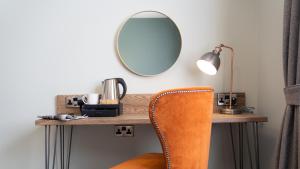 a dressing table with a mirror and a chair at Spread Eagle, Gailey by Marston's Inns in Gailey
