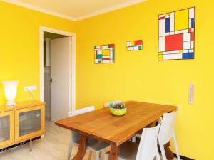 uma sala de jantar com uma mesa de madeira e uma parede amarela em Apartment Rosita by Interhome em Sant Antoni de Calonge