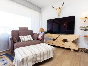 a living room with a couch and a flat screen tv at Apartment Cala by Interhome in Sant Antoni de Calonge