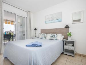 a bedroom with a white bed with blue towels on it at Apartment Pattaya-10 by Interhome in Empuriabrava
