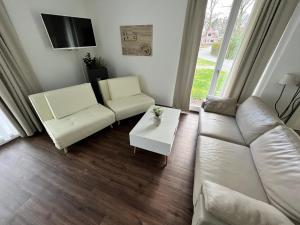 a living room with a couch and a table at Residenz - Sonnenglut - Seeterrasse - Sauna - Parkplatz in Bad Zwischenahn