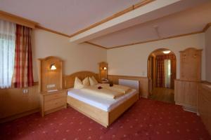 pokój hotelowy z łóżkiem i lustrem w obiekcie Panoramahotel Schwendbergerhof w mieście Hippach