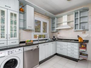 a kitchen with white cabinets and a washer and dryer at Villa Villa Juna by Interhome in Benalmádena