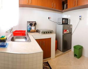 una pequeña cocina con fregadero y nevera. en MILIMANI DRIVE LIVINGs, en Kisumu
