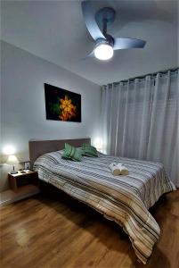 a bedroom with a bed with a ceiling fan at Apartamento Top, 3 quartos, Wi-Fi 300 Mbps in Porto Alegre