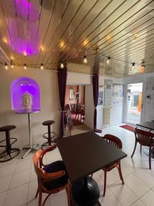 comedor con mesa, sillas y luces púrpuras en Chambres d'hôtes et Gîte Felicidade, en Mer