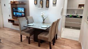 uma sala de jantar com uma mesa com cadeiras e uma televisão em Apartamento Top, 3 quartos, Wi-Fi 300 Mbps em Porto Alegre