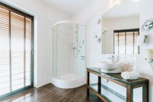 uma casa de banho branca com um lavatório e um chuveiro em Hotel Willanova em Lublin