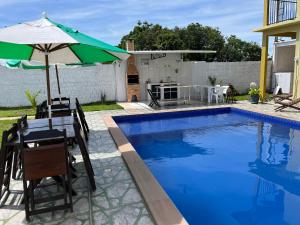 einen Tisch und einen Sonnenschirm neben einem Pool in der Unterkunft Casa Boto Tucuxi 2 in Novo Airão