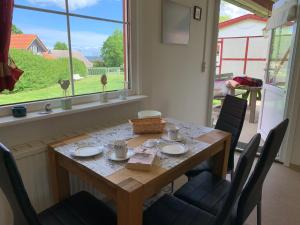 d'une table à manger, de chaises, d'une table et d'une fenêtre. dans l'établissement Ferienhäuser Wohlenberg - Baltic Cottages, à Wohlenberg