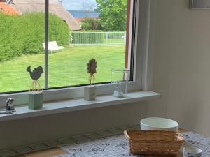 un rebord de fenêtre avec des vases et un poulet dessus dans l'établissement Ferienhäuser Wohlenberg - Baltic Cottages, à Wohlenberg 62 autres photos