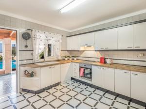 uma cozinha com armários brancos e piso em azulejo em Holiday Home Mare by Interhome em Ses Salines