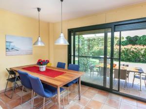 a dining room with a wooden table and blue chairs at Holiday Home Ullastreta by Interhome in Ullastret