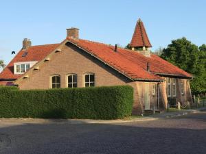 ein braunes Backsteinhaus mit rotem Dach in der Unterkunft Cadzandkerkje in Cadzand