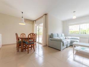 a living room with a table and chairs and a couch at Holiday Home Canyadell by Interhome in Torredembarra