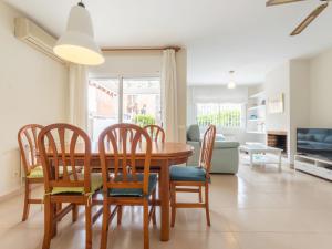 a dining room and living room with a wooden table and chairs at Holiday Home Canyadell by Interhome in Torredembarra +31 photos