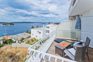 uma varanda com mesa e cadeiras e vista para a água em Rooms Carpe Diem Hvar em Hvar