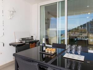 einen Balkon mit einem Tisch mit Gläsern und Weinflaschen in der Unterkunft Apartment Cala del mar by Interhome in Tossa de Mar