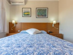 - une chambre avec un lit bleu et blanc et 2 lampes dans l'établissement Apartment L'Estel by Interhome, à Torredembarra