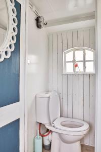 Un baño con inodoro y ventana. en Beachbus Terra Incognito, en Westerland