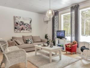 a living room with a couch and a table at Holiday Home Huvikumpu by Interhome in Hailuoto