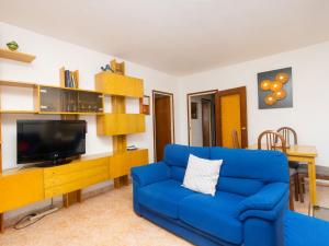 sala de estar con sofá azul y TV en Apartment Atlantis by Interhome, en Segur de Calafell