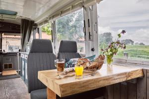 Una mesa en la parte trasera de una casa rodante con bebidas. en Beachbus Terra Incognito, en Westerland 4 fotos más