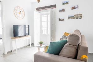 een woonkamer met een bank en een tv bij Casa Rehala by Cadiz Time in Cádiz
