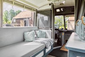 Un banco en una casa rodante con almohadas encima. en Beachbus Terra Incognito, en Westerland