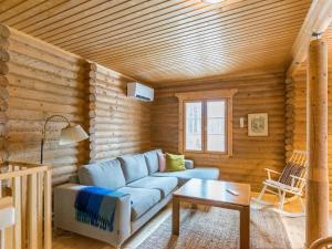 a living room with a blue couch and a table at Holiday Home Hiljanrinne by Interhome in Haminankylä