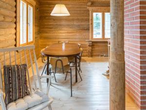 a wooden dining room with a table and chairs at Holiday Home Hiljanrinne by Interhome in Haminankylä