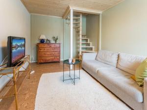 a living room with a couch and a television at Holiday Home Hiljanrinne by Interhome in Haminankylä