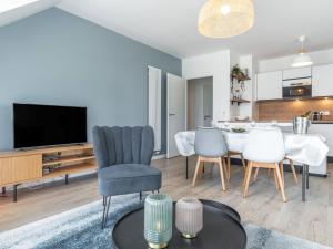 sala de estar con mesa, sillas y TV en Apartment Les Villas du Men Du-1 by Interhome en Carnac
