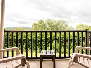 um alpendre com 2 cadeiras e uma mesa na varanda em Apartment Les Corniches du Mont Canisy by Interhome em Blonville-sur-Mer