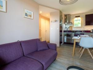 uma sala de estar com um sofá roxo e uma cozinha em Apartment Les Corniches du Mont Canisy by Interhome em Blonville-sur-Mer